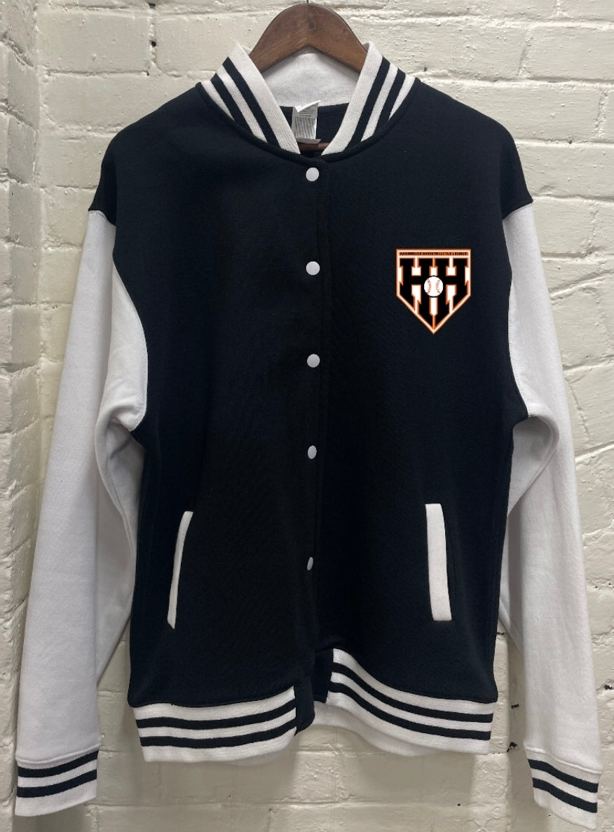 Navy and white varsity jacket with a logo on a hanger against a brick wall.